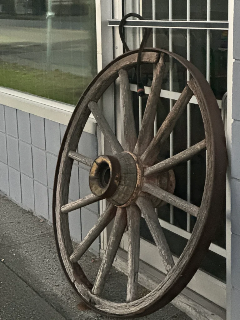 Rustic wooden wagon wheel outside a local shop in Cloverdale reflecting small-town charm and craftsmanship.